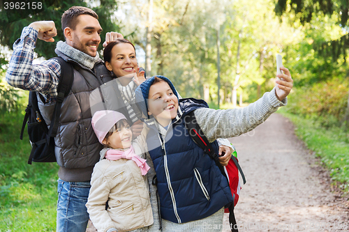 Image of family with backpacks taking selfie by smartphone