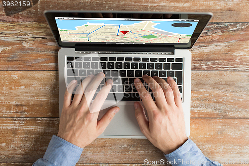 Image of close up of male hands with laptop typing