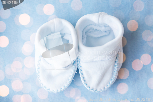 Image of close up of baby bootees for newborn boy on blue