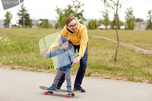 Image of happy father and little son on skateboard