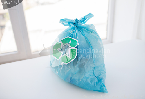 Image of close up of rubbish bag with green recycle symbol