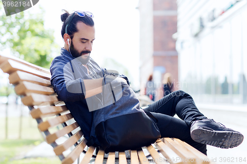 Image of man with backpack and earphones in city