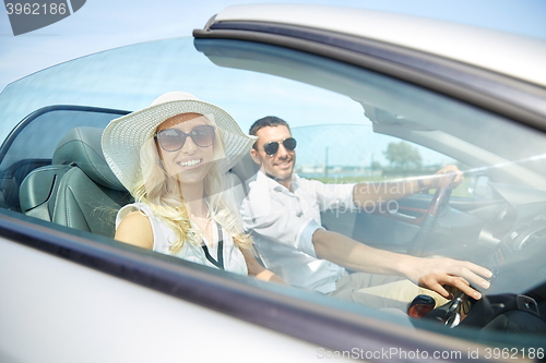 Image of happy man and woman driving in cabriolet car