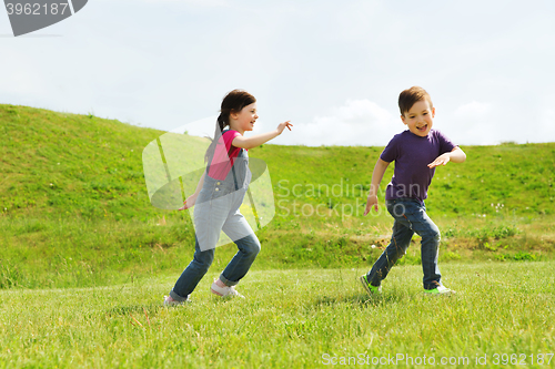 Image of happy little boy and girl running outdoors