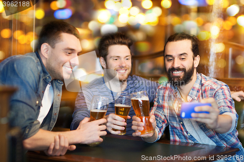 Image of friends taking selfie and drinking beer at bar