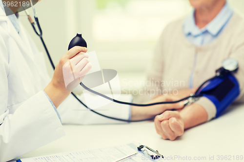 Image of doctor with tonometer and senior woman at hospital