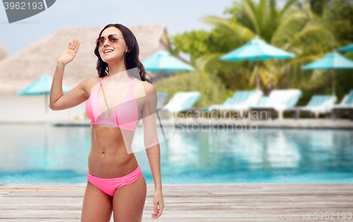 Image of happy woman in sunglasses and bikini on beach
