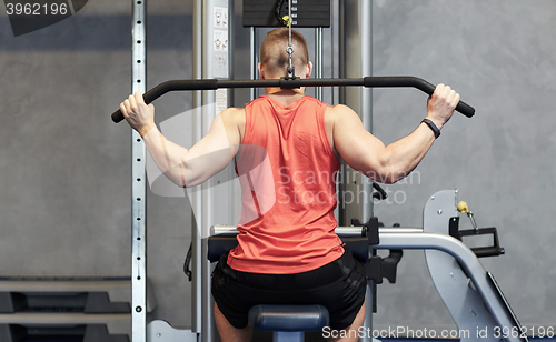 Image of man flexing muscles on cable machine gym