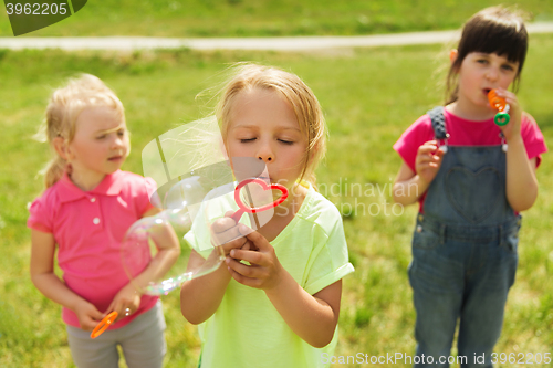 Image of group of kids blowing soap bubbles outdoors