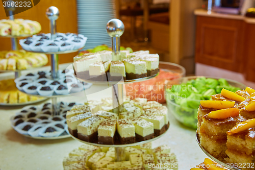 Image of Dessert table for party. akes and sweetness. Shallow dof