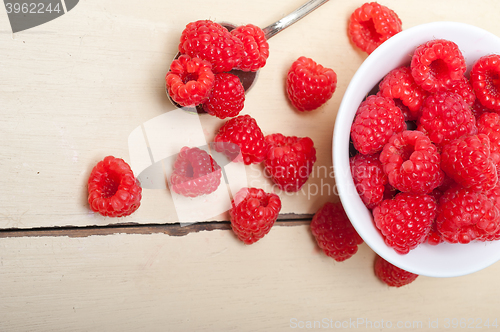 Image of bunch of fresh raspberry on a bowl and white table