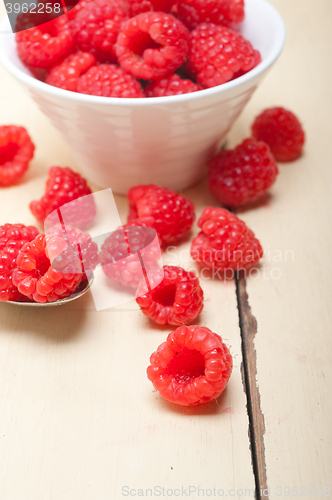 Image of bunch of fresh raspberry on a bowl and white table