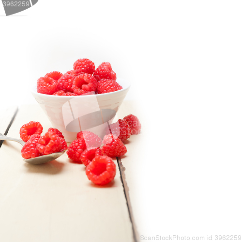 Image of bunch of fresh raspberry on a bowl and white table