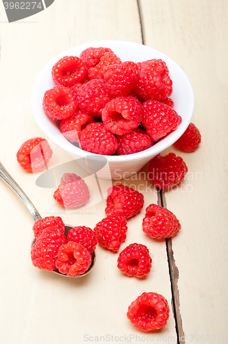 Image of bunch of fresh raspberry on a bowl and white table