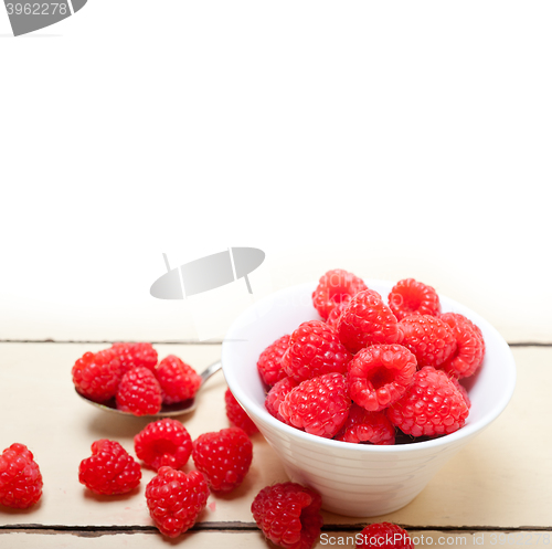 Image of bunch of fresh raspberry on a bowl and white table