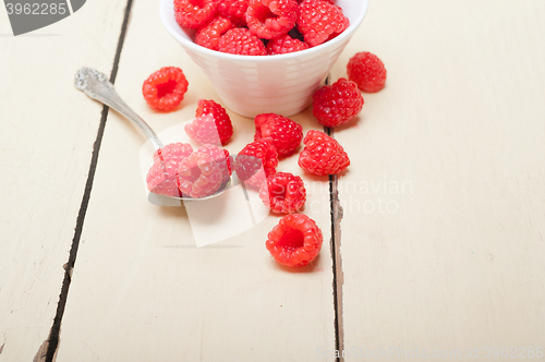 Image of bunch of fresh raspberry on a bowl and white table