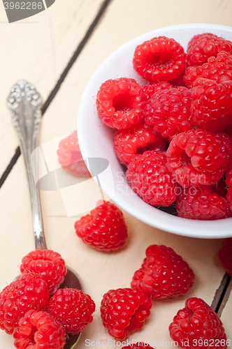Image of bunch of fresh raspberry on a bowl and white table