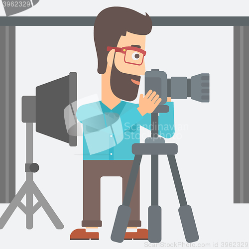 Image of Photographer working with camera on a tripod.