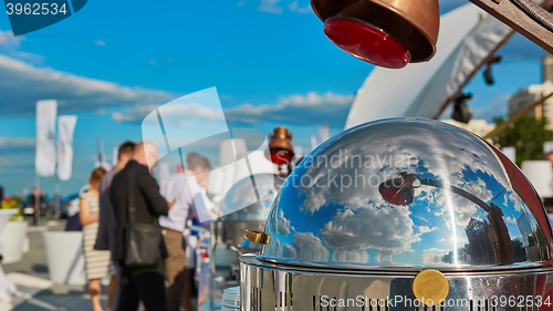 Image of Table with dishware and marmites waiting for guests.