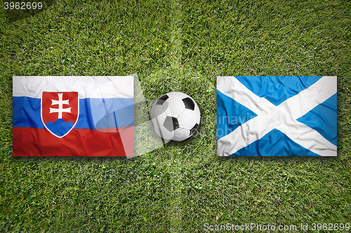 Image of Slovakia vs. Scotland flags on soccer field