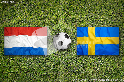 Image of Netherlands vs. Sweden flags on soccer field