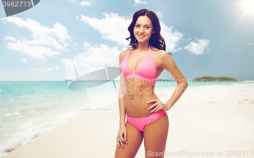 Image of happy woman in pink bikini swimsuit on beach