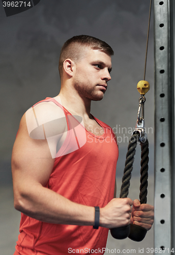 Image of man flexing muscles on cable machine gym