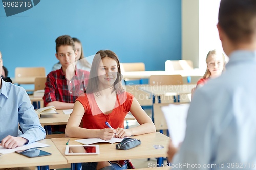 Image of group of students and teacher with papers or tests