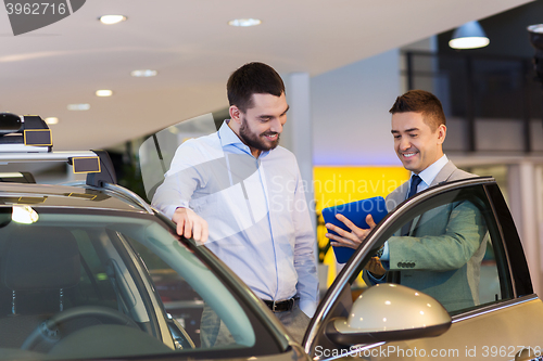 Image of happy man with car dealer in auto show or salon