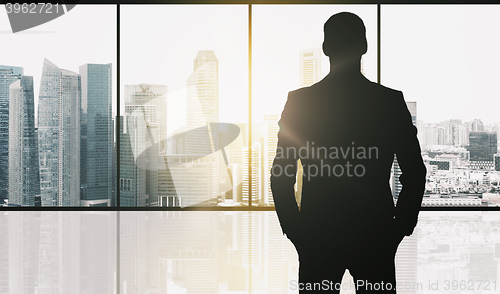 Image of silhouette of business man over office background