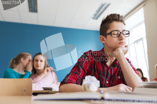 Image of students gossiping behind classmate back at school