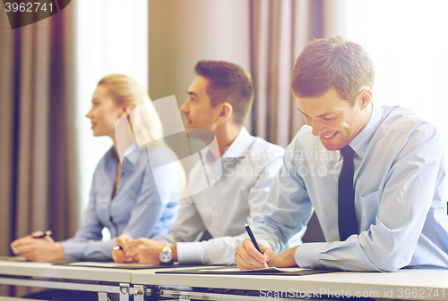 Image of group of smiling businesspeople meeting in office