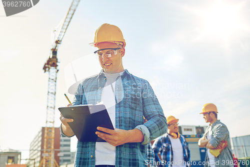 Image of builder in hardhat with clipboard at construction