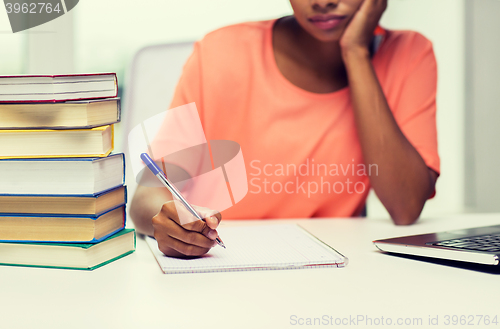 Image of close up of woman with laptop and books at home