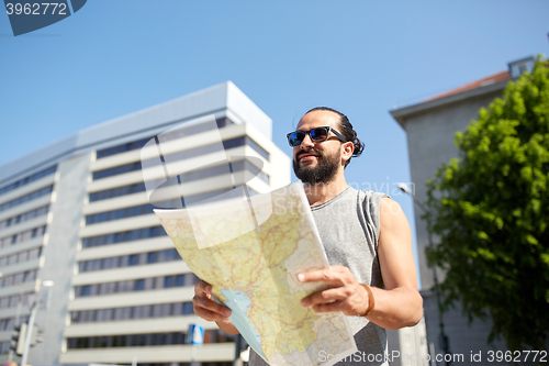Image of man traveling with backpack and map in city