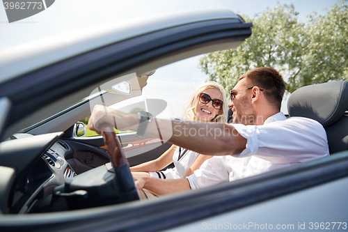 Image of happy man and woman driving in cabriolet car