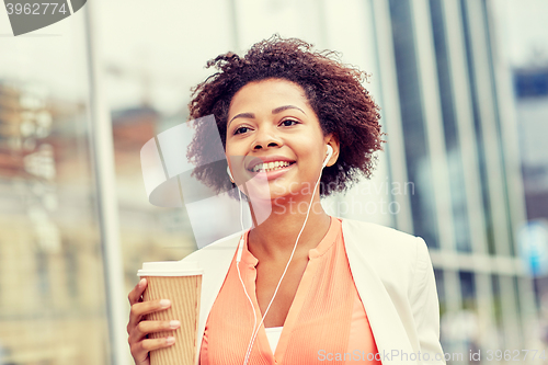 Image of happy african businesswoman with coffee in city