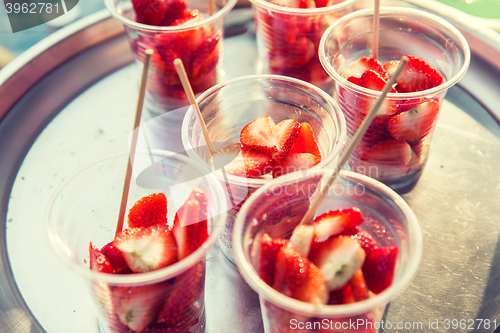 Image of strawberry in plastic cups at street market