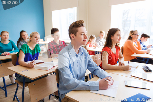 Image of group of students with notebooks at school lesson