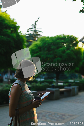 Image of woman drinking coffee and looking at phone