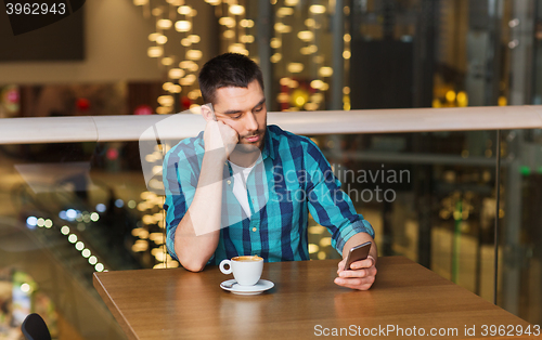 Image of man with smartphone and coffee at restaurant