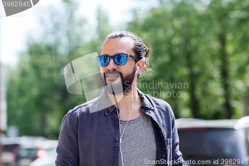 Image of man with earphones listening to music in city