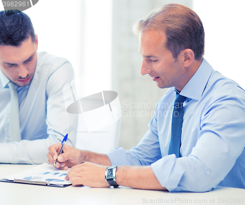 Image of businessmen with notebook on meeting