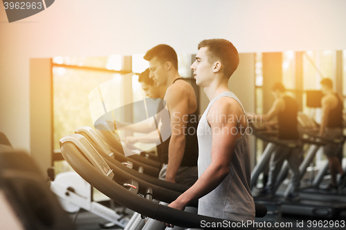 Image of group of men exercising on treadmill in gym