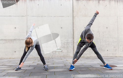 Image of close up of couple stretching on city street