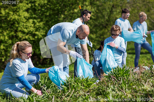 Image of volunteers with garbage bags cleaning park area