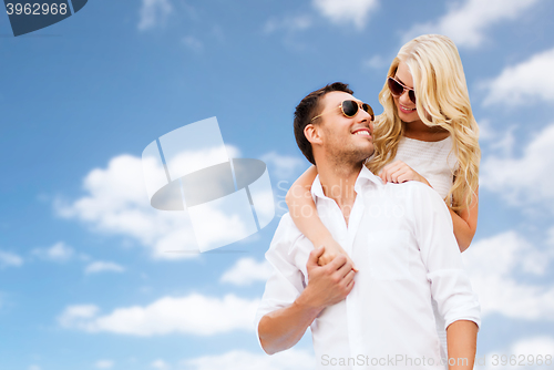 Image of happy couple in sunglasses over blue sky