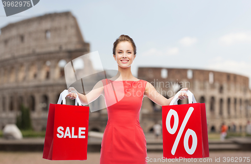 Image of woman with red shopping bags over coliseum