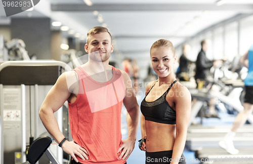 Image of smiling man and woman in gym