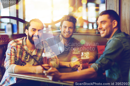 Image of friends taking selfie and drinking beer at bar